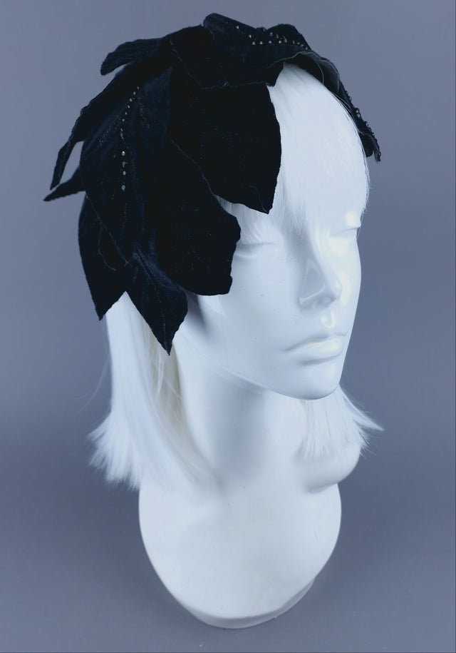 A black velvet leaf headdress featuring glittered leaves and a wired base.