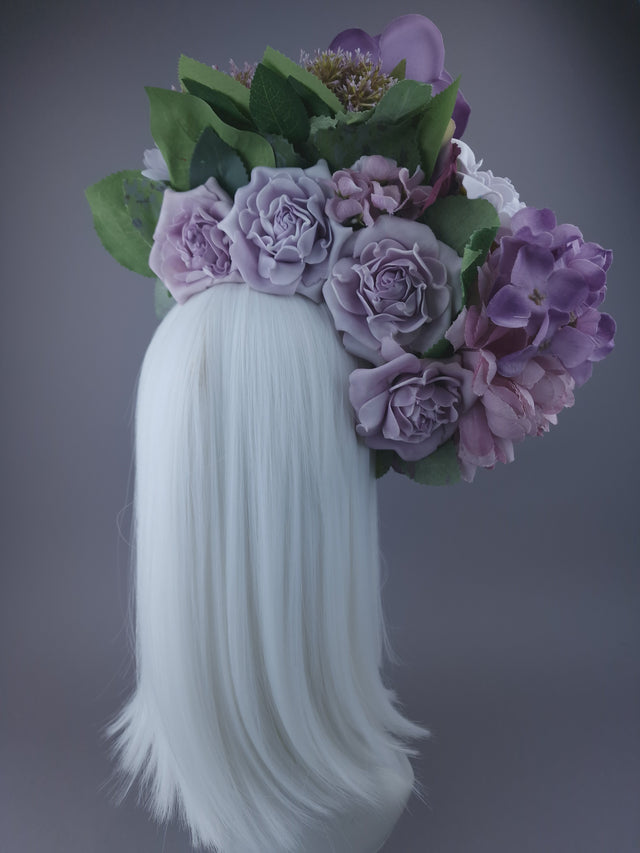 Oversized purple and mauve flower headdress. photo from behind