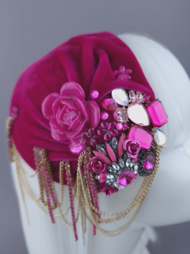 close up of a vintage-inspired, pink velvet hat embellished with jewels & delicate chain.