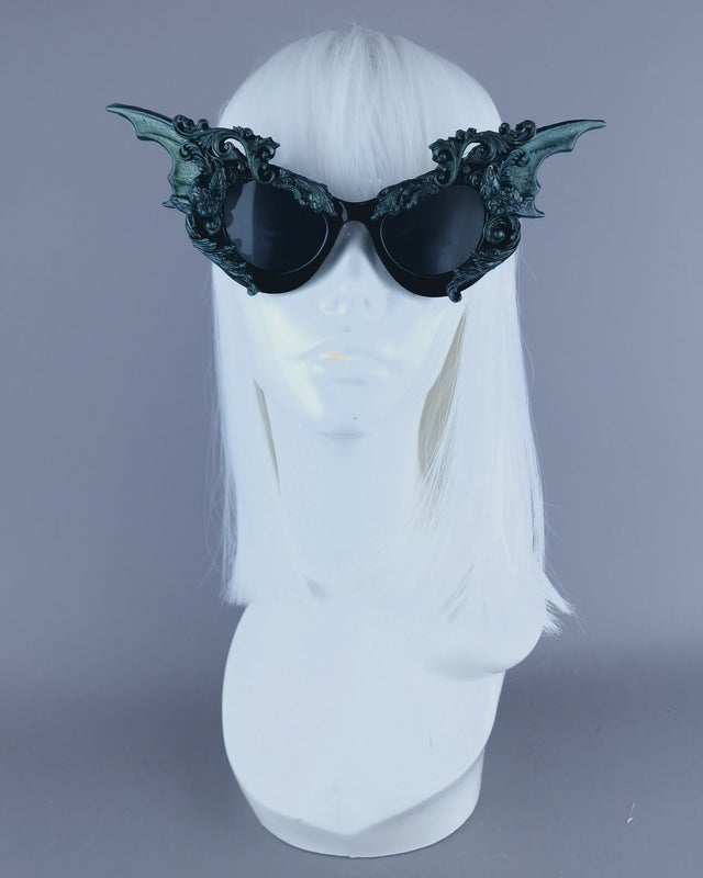 Ornate iridescent teal filigree sunglasses with cherub and bat wing designs