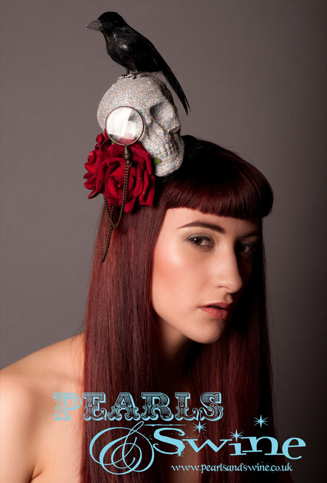 Skull and Raven Fascinator "Edgar's Raven" Diamond glittered skull set on a black glittered base, decorated with a monocle and chain, red velvet roses and a black feathered crow or raven. Inspired by Edgar Allen Poe's "The Raven" This is a piece of wearable art which could be displayed in a cabinet when not worn, it is backed with leopard print satin and attaches with a comb and adjustable hat elastic. Perfect for Edgar Allen Poe fans and goth fashion lovers.