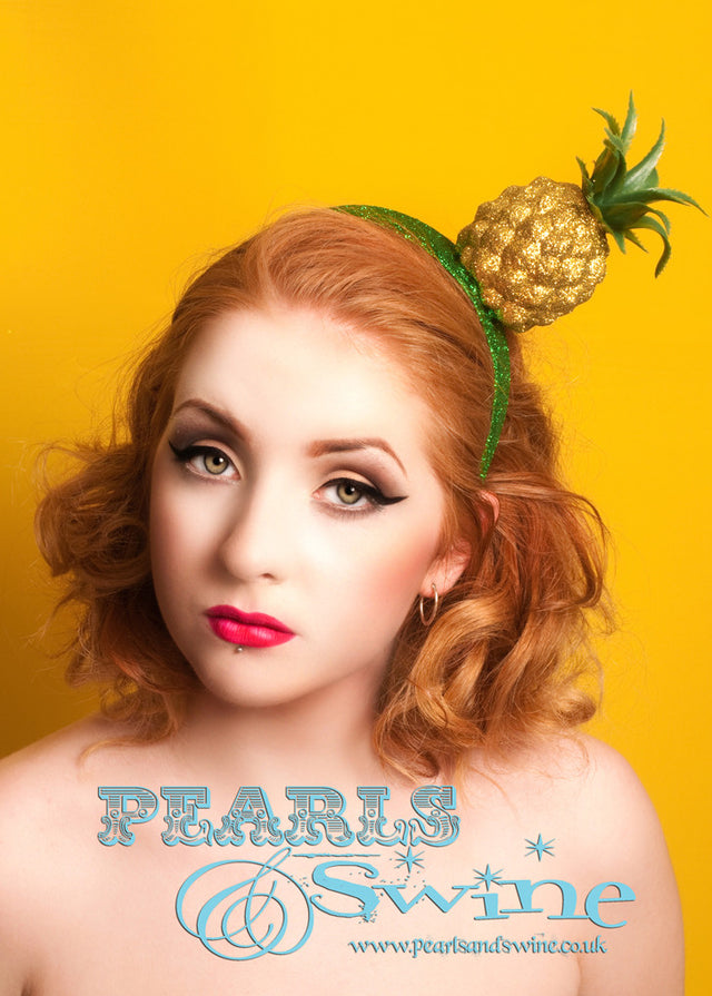 Gold glitter pineapple headpiece set on glittered green headband. Lightweight, this pineapple headpiece is fun and easy to wear. Can be worn on either side! Perfect for those who love Carmen Miranda, fruit hats or tiki or rockabilly fashion.