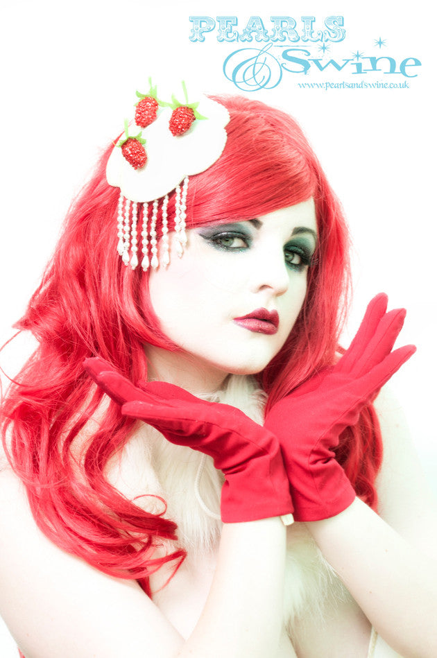 Strawberries and cream fascinator covered in glitter, decorated with artificial strawberries. The headpiece is edged in pearl sequin and dripping with pearl fringe beading. Made using hand blocked millinery felt, backed with leopard print satin, attaches with a comb and adjustable hat elastic. Perfectly summery and retro kitsch!