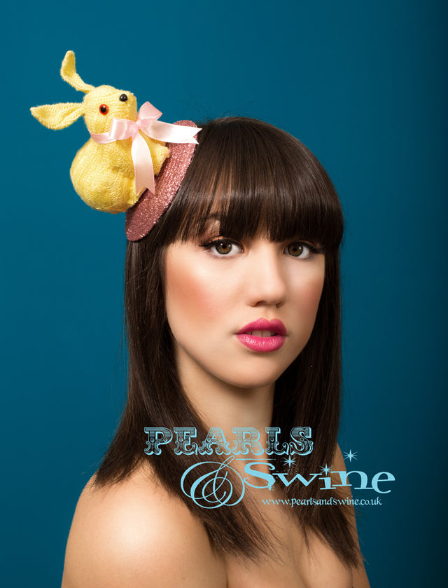 Yellow knitted bunny in a pretty pink bow set on a hand glittered pink fascinator base, backed with leopard print satin. Attaches with a comb and hat elastic. A lovely Easter bonnet or perfect for bunny rabbit lovers! LIMITED EDITION.