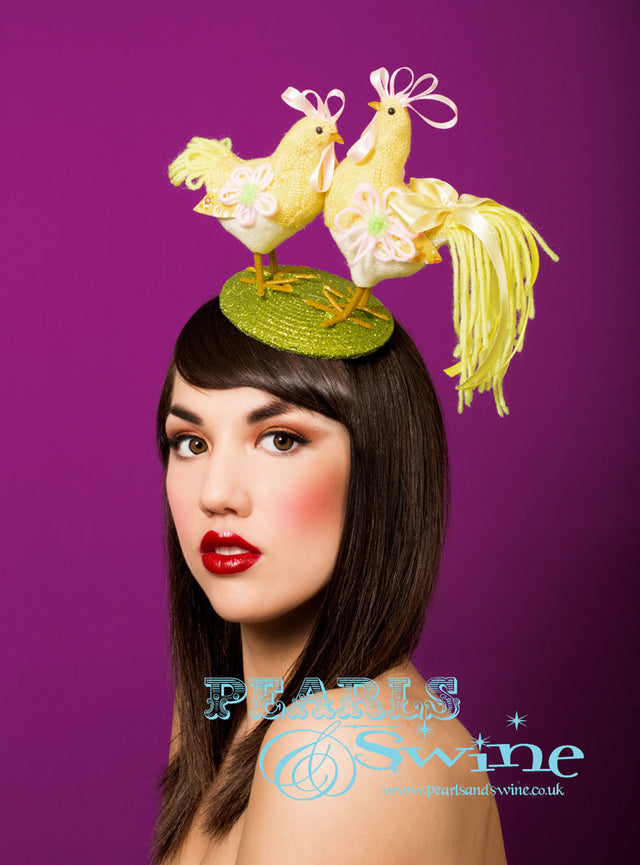 Lime green glitter fascinator decorated with a yellow, knitted chicken and rooster. The base backed with leopard-print satin. Attaches with a comb and adjustable hat elastic.  This is a perfect quirky Easter bonnet, ideal for someone who loves chickens.