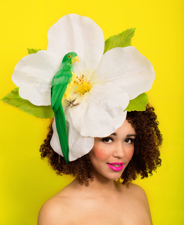 Giant tropical sparkly ivory flower with green parrot perched on it. This is set on a fascinator base decorated with leaves.This attaches with a comb and adjustable hat elastic, this is comfortable for all day wearing.  Perfect for Ladies Day at Royal Ascot or a wedding or rock & roll bride. 