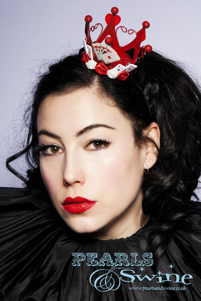 Red Mini Crown "Queen of Hearts" Red mini metal crown, decorated in roses, bows, playing cards, and symbols. This queen of hearts inspired crown attaches with a comb and adjustable hat elastic. Perfect for an Alice in Wonderland inspired outfit.