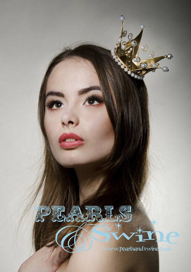 Metallic gold mini crown decorated by hand with clear crystals and pearls. Attaches with a comb and hat elastic. Perfect for a bride!