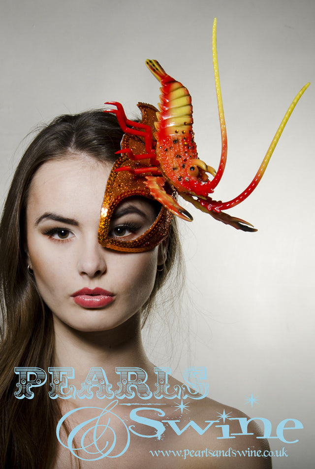 Orange glitter surreal lobster half mask fascinator creation is inspired by Salvador Dali. Made using hand blocked millinery felt backed with leopard print satin fabric, edged with orange sequin and sprinkled with orange crystals. The lobster is sprinkled in orange crystals, the feelers that move when you wear this so you bring the lobster to life. Attaches with a comb, extra bobby pins will help keep firmly in place.