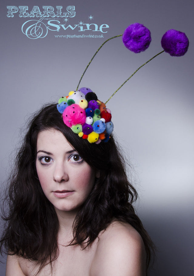 Unusual lime glittered feelers on a pompom covered base, sprinkled in multi coloured crystals. This pom pom feelers headpiece base is backed with leopard print satin. Attaches with a comb and adjustable hat elastic.
