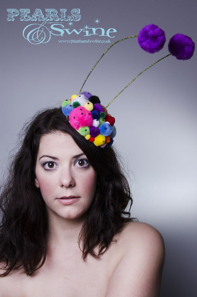 Unusual lime glittered feelers on a pompom covered base, sprinkled in multi coloured crystals. This pom pom feelers headpiece base is backed with leopard print satin. Attaches with a comb and adjustable hat elastic.
