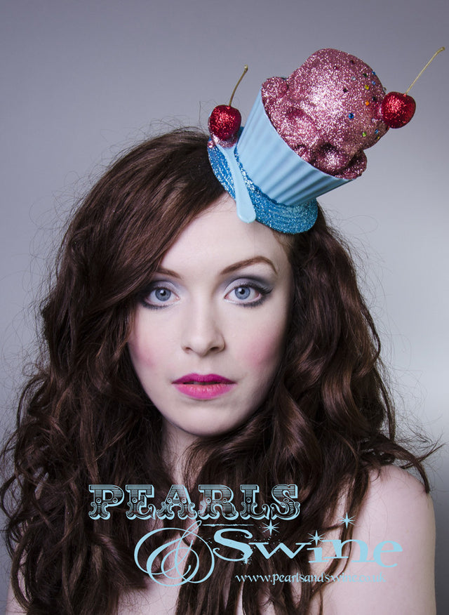 Pink glitter ice cream skull in a bowl with a spoon and glittered cherries, sprinkled in multi coloured crystals on a blue glitter fascinator base. The base is backed with leopard print satin and attaches to the hair with a comb and adjustable hat elastic. The perfect zero calorie ice cream!