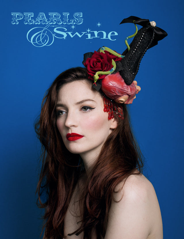 Anatomical heart hat, being crushed by a black glittered high heel shoe, decorated with a skull bow and black gems. This one of a kind, anatomical heart hat also has red velvet roses, a snake, and drips with red fringe beading. Attaches with a comb and adjustable hat elastic. This Halloween style hat is perfect for heart-breakers and devil-women. It's a piece of wearable art, a wicked take on Schiaparelli's shoe hat. The sort of Halloween hat you want to keep on display in a glass cabinet all year round.