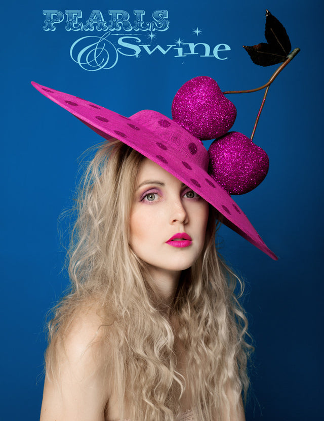 Wide brimmed fuchsia pink sinamay hat covered in pink glitter polka dots, decorated with two fuchsia glittered giant cherries on top. Set on a headband for comfortable secure wearing. Can be secured with extra bobby pins if needed. This headpiece can be made in other colours to match your outfit, just message me to ask. The giant cherries hat is perfect for Ladies Day at Royal Ascot or a wedding. It's joyfully flamboyant and fun.