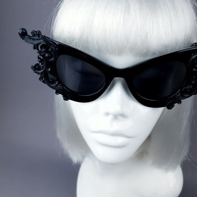 Close up of hand-decorated black filigree ornate sunglasses.