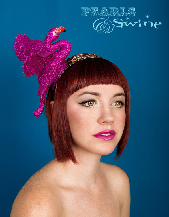 Flamboyant fuchsia pink glittered flamingo set on a wide leopard print satin headband. The wings even move slightly when you walk!! Perfect for Ascot Ladies Day, The Doncaster Races, York Races, Kentucky Derby or an Alice in Wonderland inspired costume.