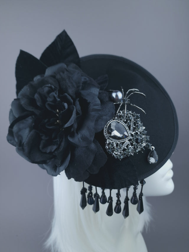 Black felt hat with black roses, fringe beading & velvet leaves. Decorated with a spider and a large sparkling jewel.  