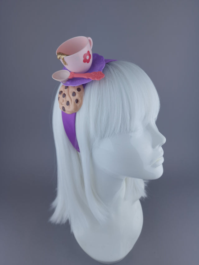 quirky purple headband with pink tea cup, purple saucer, pink spoon and cookie. Gold glitter detail to imitate tea