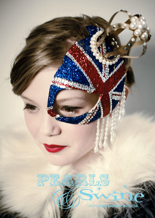 Union Jack Half Mask Fascinator "Regency"  This half mask fascinator has a  glittered Union Jack with a gold crown decorated in pearls, crystals, and pearl beading. Attaches with a comb.