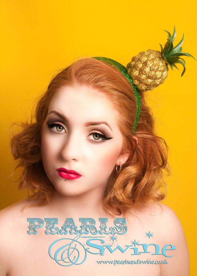 Gold glitter pineapple headpiece set on glittered green headband. Lightweight, this pineapple headpiece is fun and easy to wear. Can be worn on either side! Perfect for those who love Carmen Miranda, fruit hats or tiki or rockabilly fashion. 