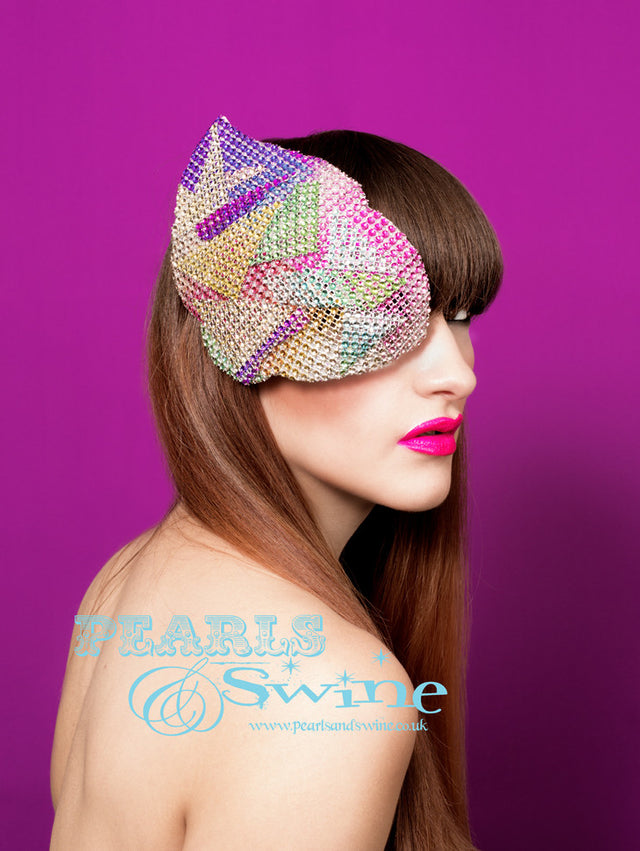 Sparkly rainbow metallic mesh covered, glam rock inspired half mask fascinator which you can also wear as an elaborate eyepatch! You can't see in but you can see out. This mask is blocked by hand and backed with leopard print satin and attaches with a comb and adjustable hat elastic. I love how space age/glam rock/David Bowie/70s/80's this mask is, it's a really unique fashion statement. 