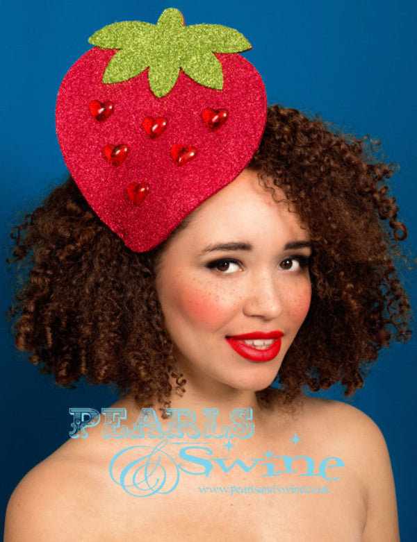 A huge, sparkly, hand molded felt strawberry decorated with glitter and red heart gems set on a fascinator base.  Attaches with a comb and adjustable hat elastic.