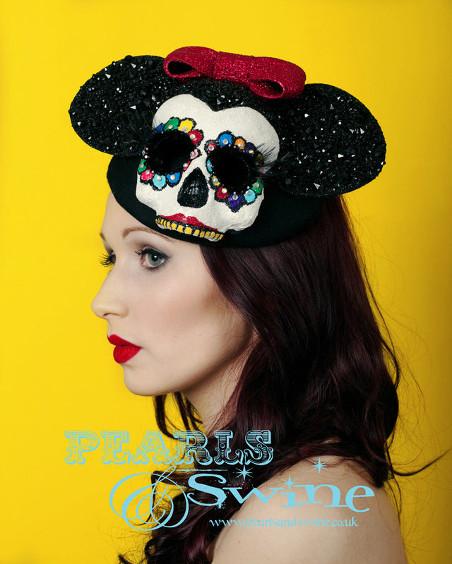 This mouse hat is inspired by the Mexican Day of the Dead. It has a glittered, hand-painted crystal skull with long 3D eyelashes, black gem covered mouse ears and a red glitter bow on a black vintage-style felt hat base. Attaches with a comb and adjustable hat elastic.  The hat also doubles as a piece of art that you can display in a cabinet or on your wall. I recommend keeping it free of dust as it's heavily glittered but it's too pretty to keep hidden away. Perfect for Royal Ascot Ladies Day.