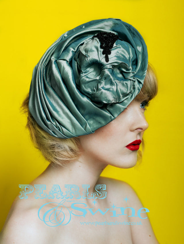 One of a kind hat featuring a skull emerging from beneath an iridescent two toned green/teal taffeta fabric. This hat was inspired by the gorgeous TV series "Penny Dreadful", i don't know how or even why but that is how it works sometimes. This hat attaches with a comb and adjustable hat elastic, it's backed with taffeta. Perfect for lovers of Victorian fashion or goth fashion.
