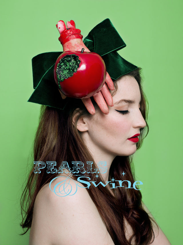 One of a kind Halloween fascinator, featuring a giant emerald green velvet bow, dismembered hand holding a shiny red bitten apple oozing green glitter "poison". Attaches with a comb and adjustable hat elastic.