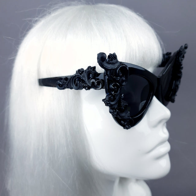 Decorative arm of hand-decorated black filigree ornate sunglasses.