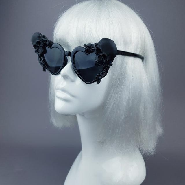 Side view of hand-decorated, customised, ornate heart-shaped sunglasses with skulls and filigree. Displayed on a mannequin head